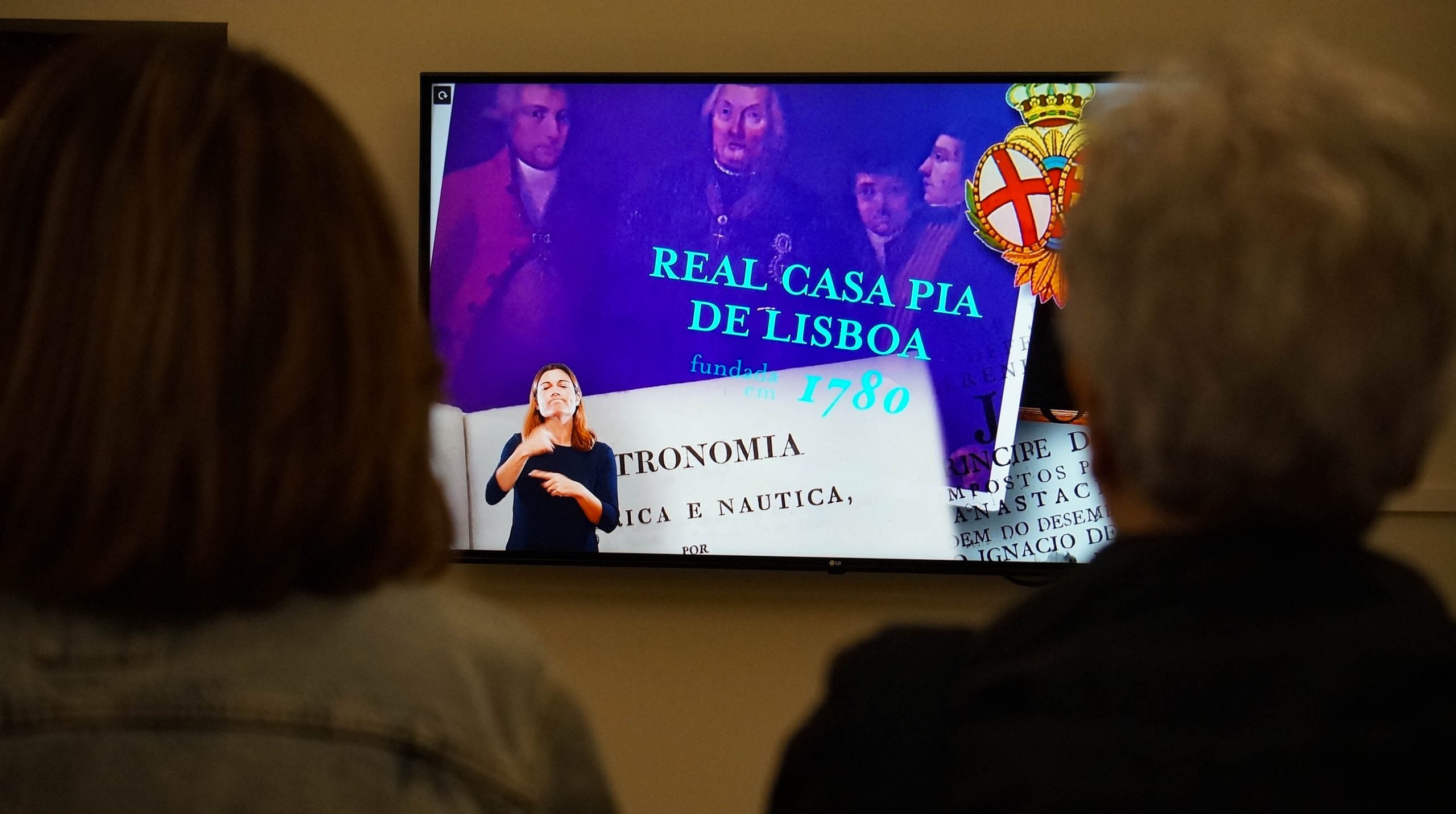 Duas visitantes assistem ao vídeo institucional da Casa Pia de Lisboa