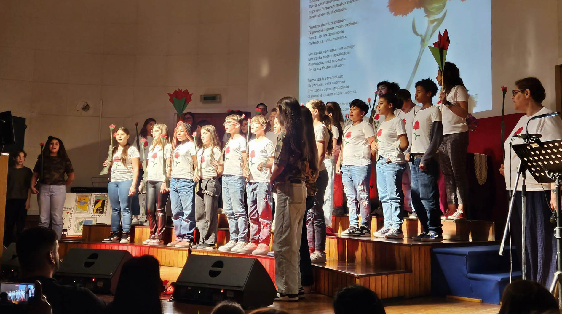 Muitas crianças e jovens no palco a cantar