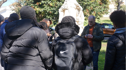 Seis pessoas ao pé da estátua "Piedade" no CED PM