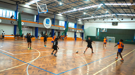 jovens a jogar futsal com fundo da casa pia de lisboa suspenso no pavilhão